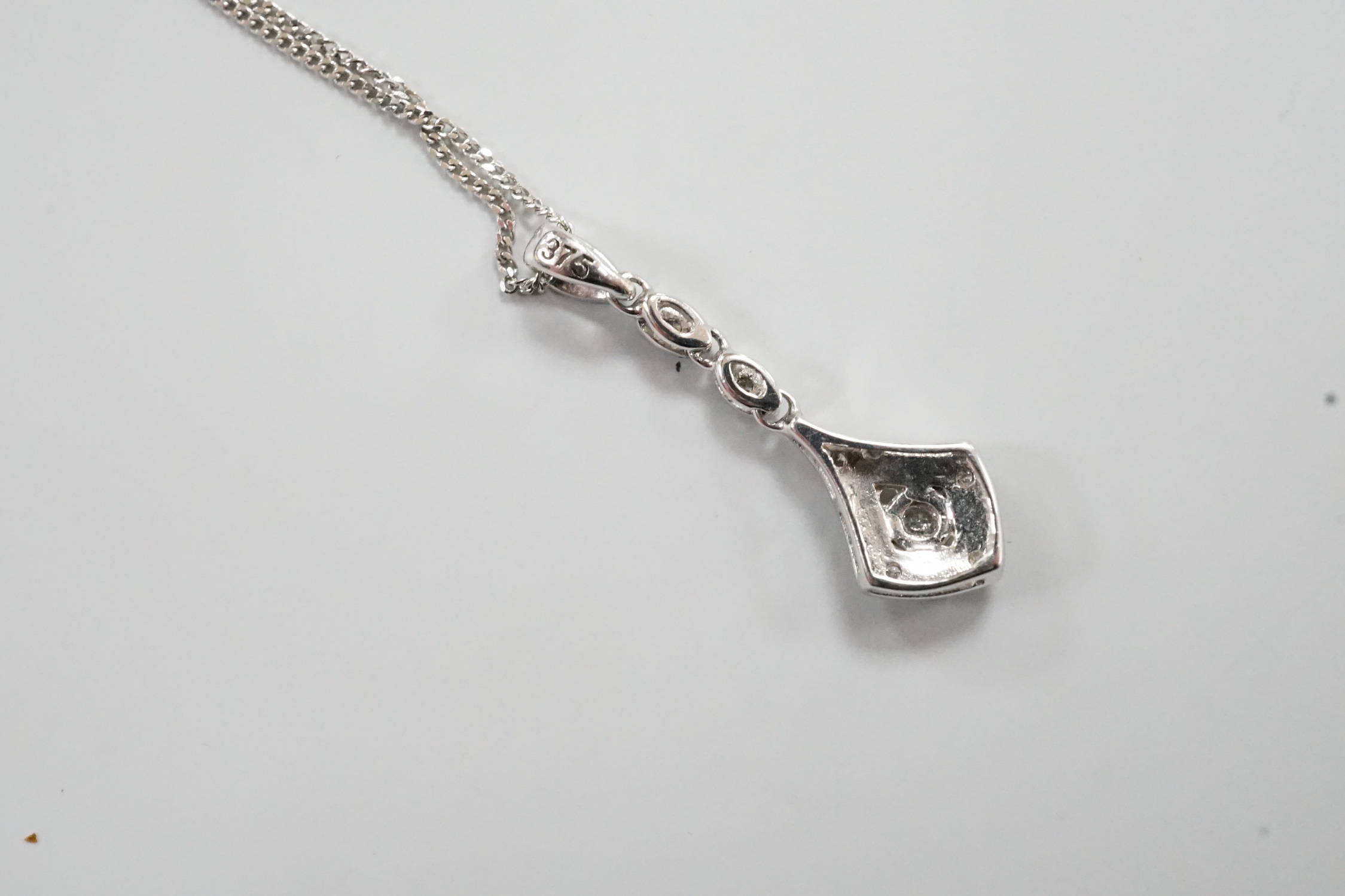 A modern 375 white metal and diamond chip set drop pendant, 23mm, gross 0.6 grams on an 18ct white gold chain, 46cm and one other 18ct white gold chain, 40cm, 18ct gross 2.9 grams.